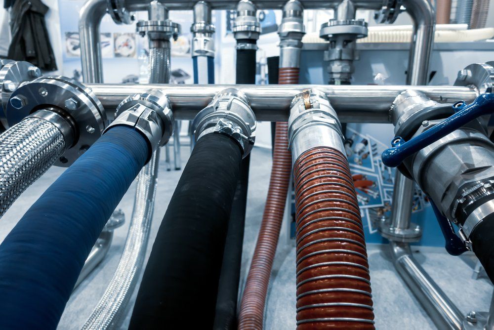 A bunch of pipes and hoses are lined up on a table.