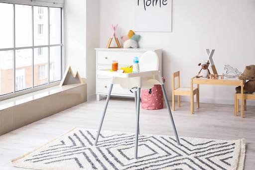 A high chair is sitting on a rug in a child 's room.