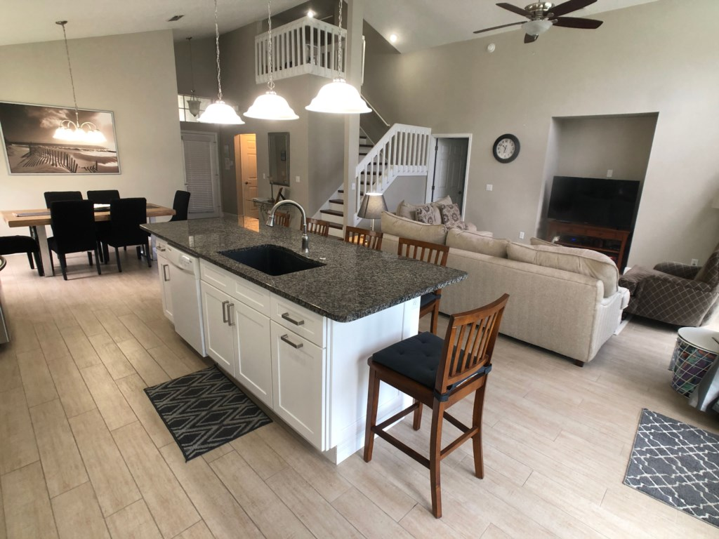 A kitchen with granite counter tops and white cabinets
