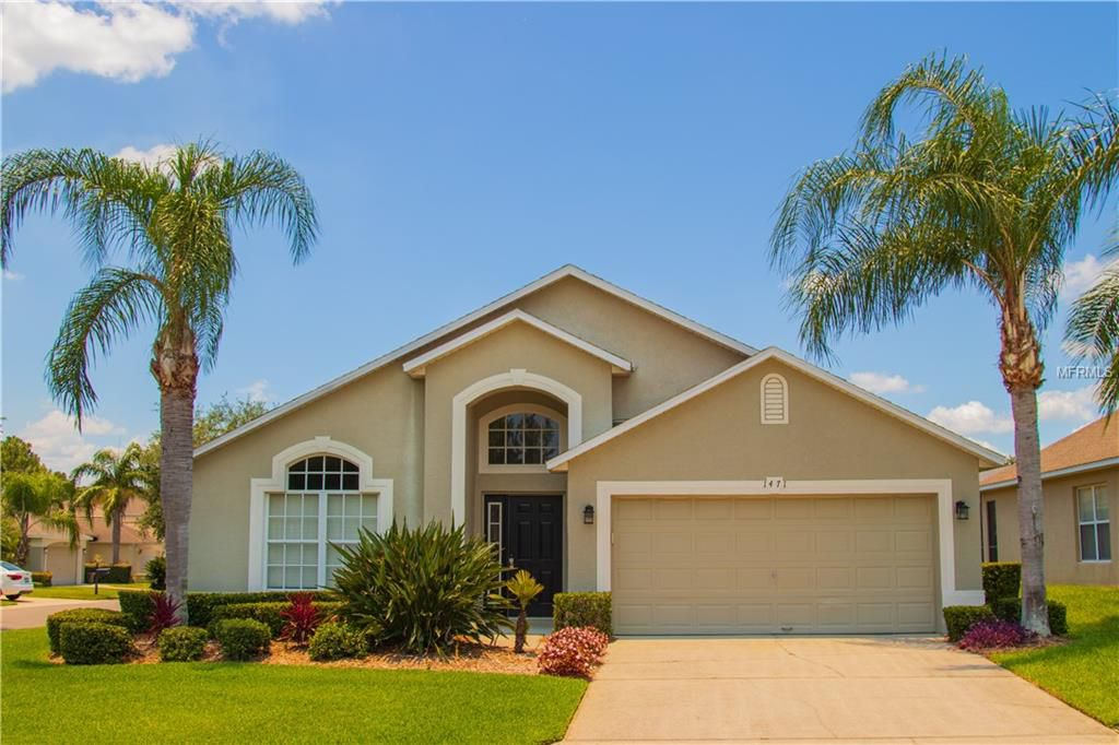 A house with two palm trees in front of it