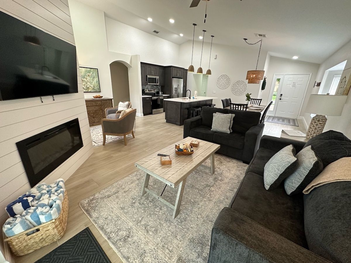 A house with a white garage door is surrounded by palm trees