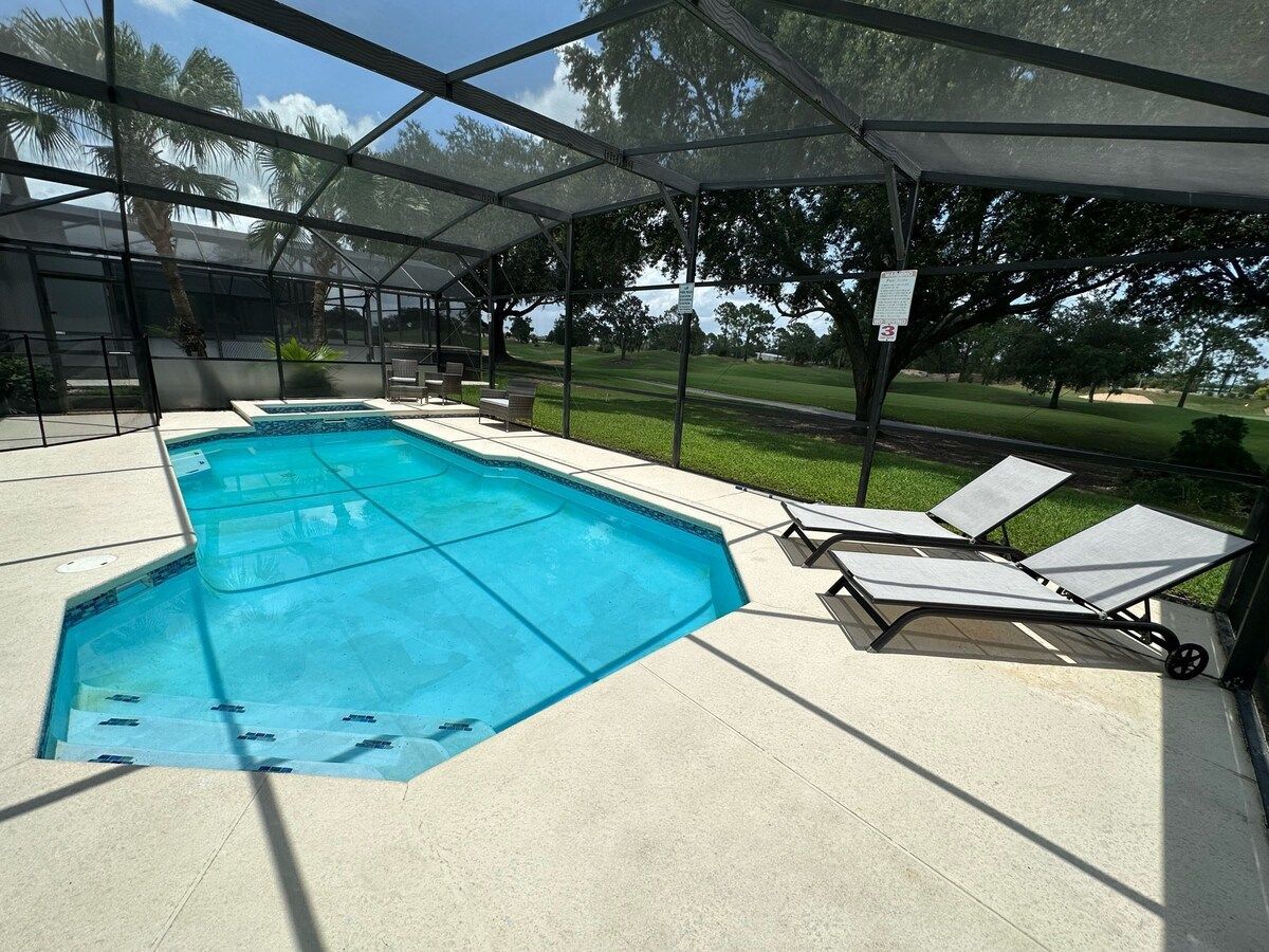 A blue house with a white garage door and palm trees in front of it.