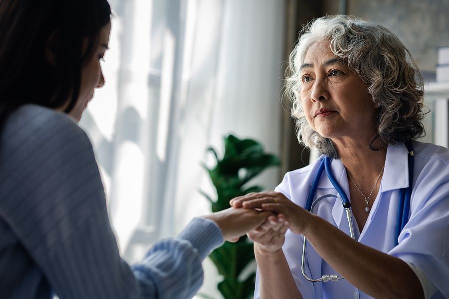 nurse holding a young homeless woman's hand