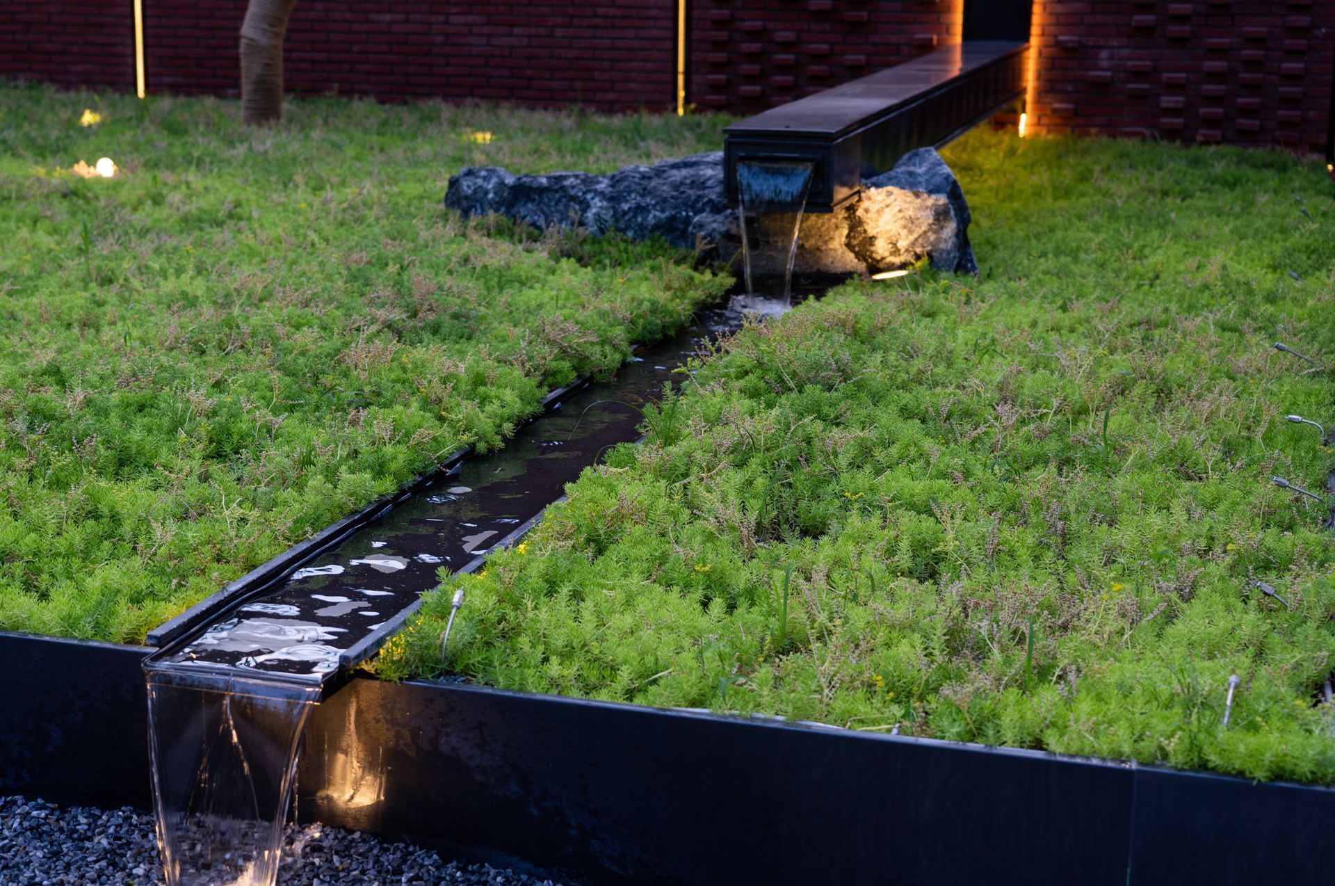 Stone path winds through lush, green hillside garden.