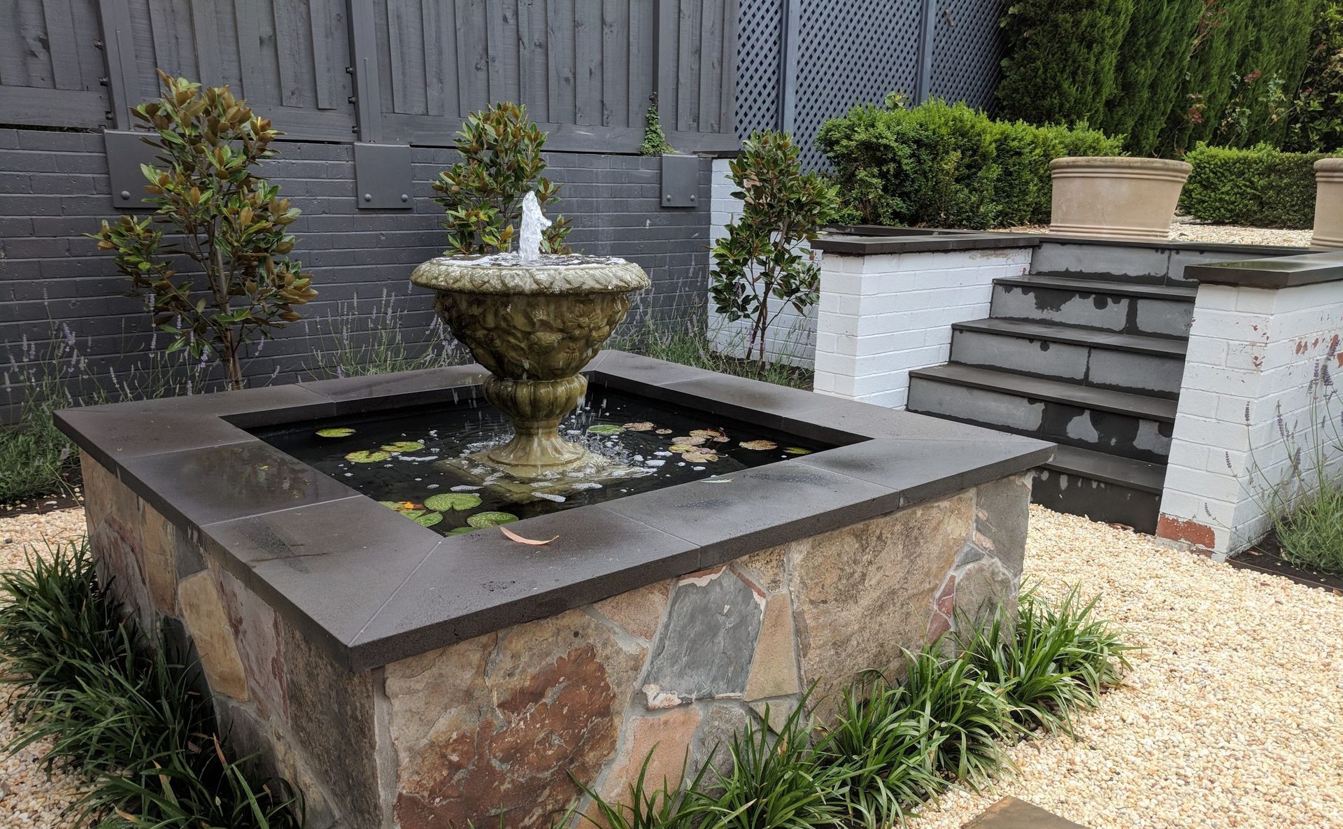 Green field with trees and distant hills under a blue sky, lit by golden sunlight.
