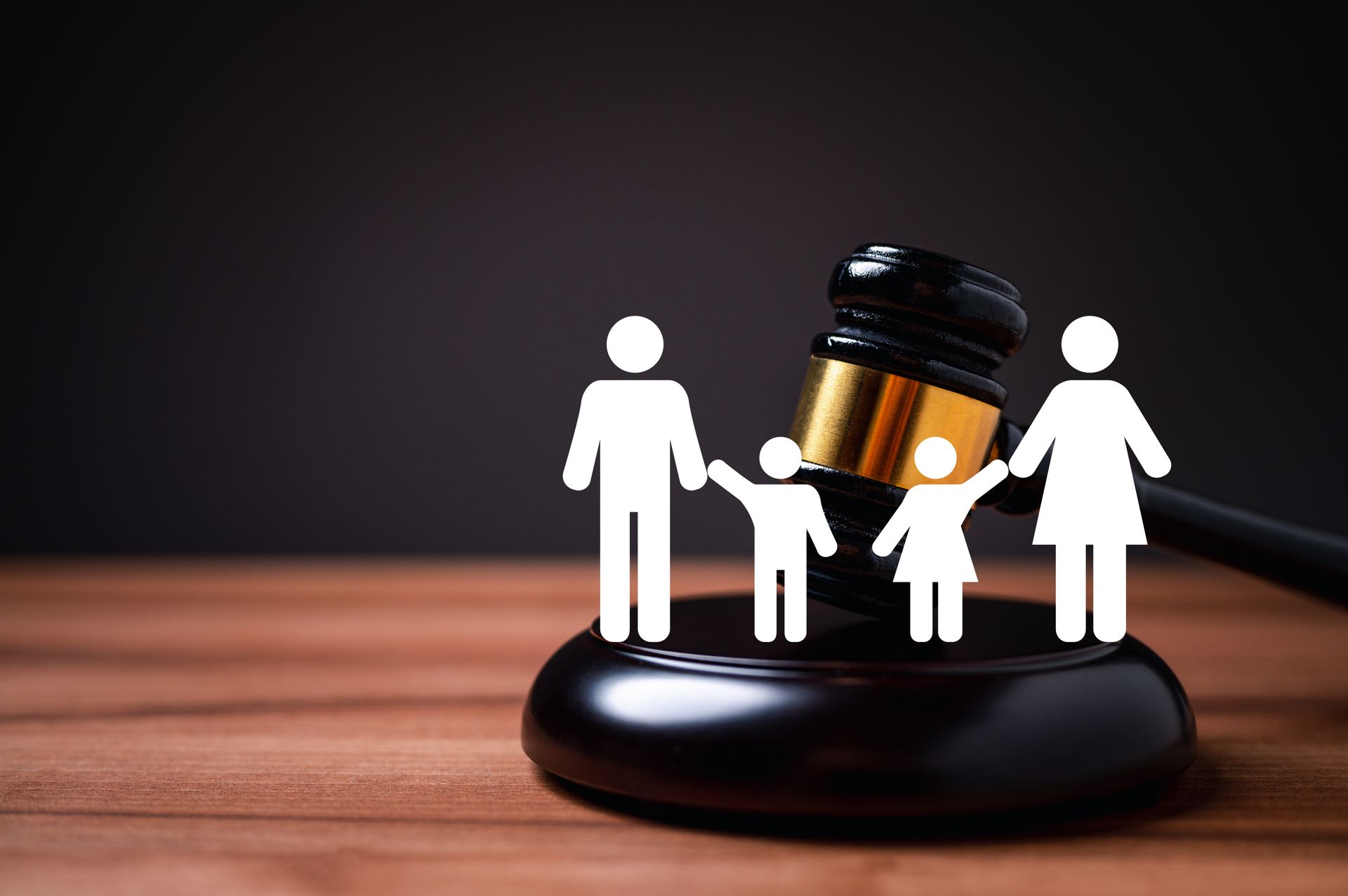 A family is sitting on top of a judge 's gavel on a wooden table.