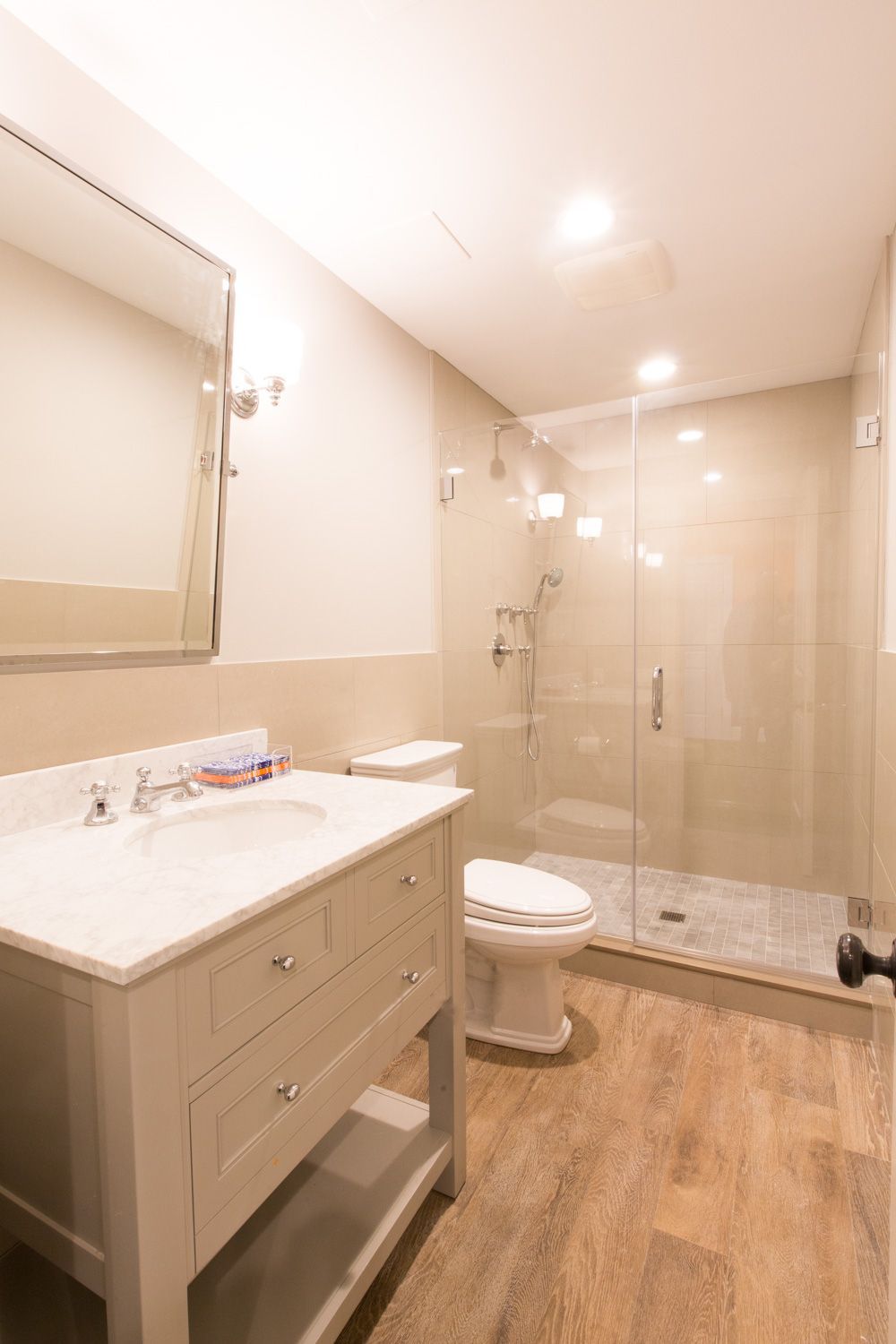 Bathroom with white vanity, toilet, and glass shower