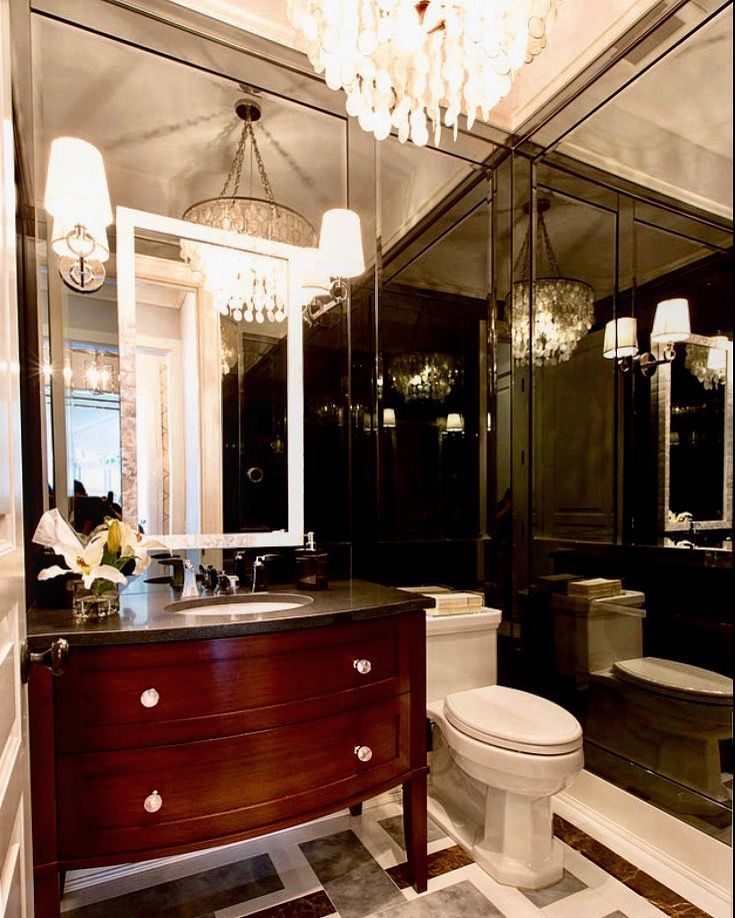 A luxurious powder room with dark mirrors