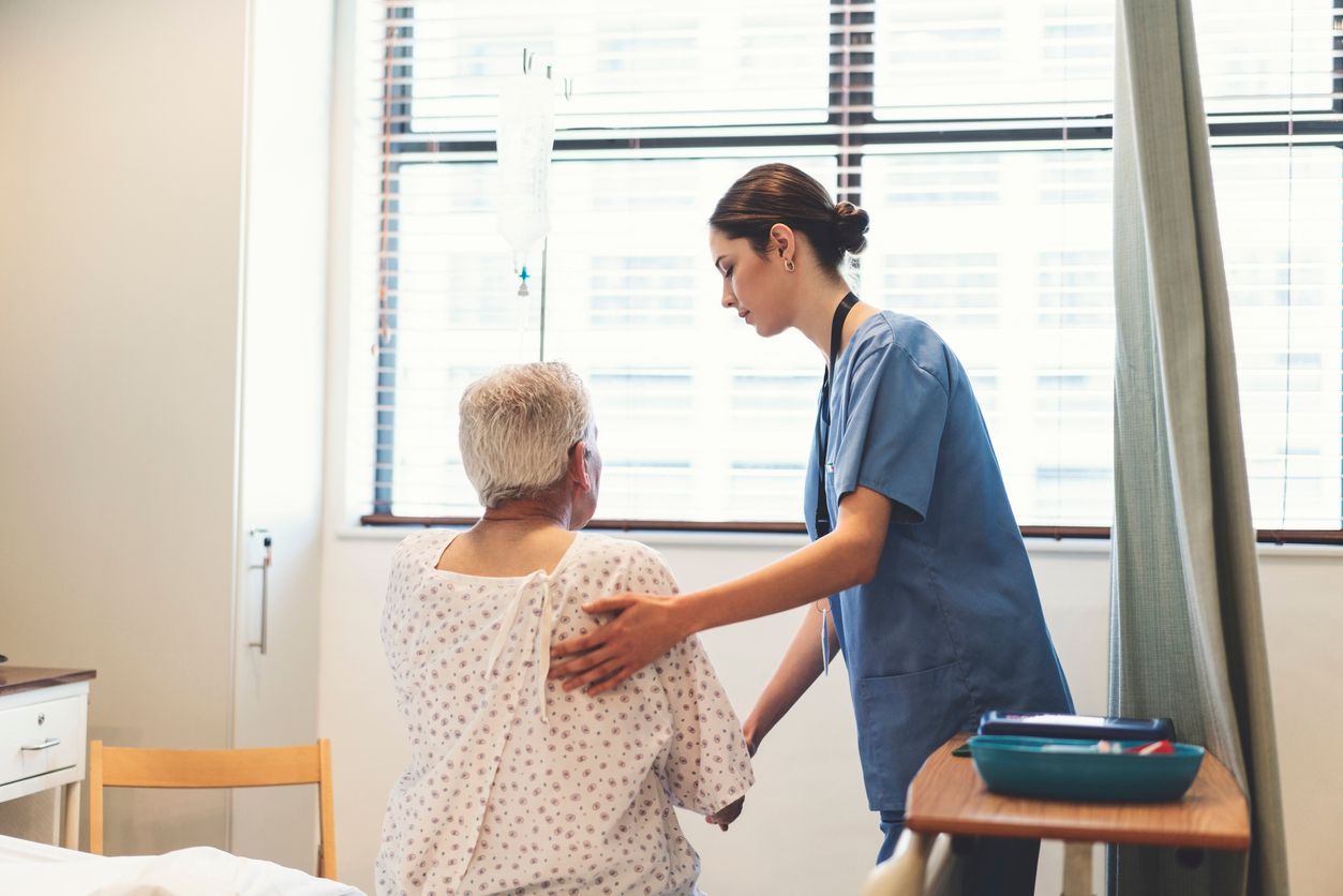 Nurse assisting a senior patient in the hospital ward.