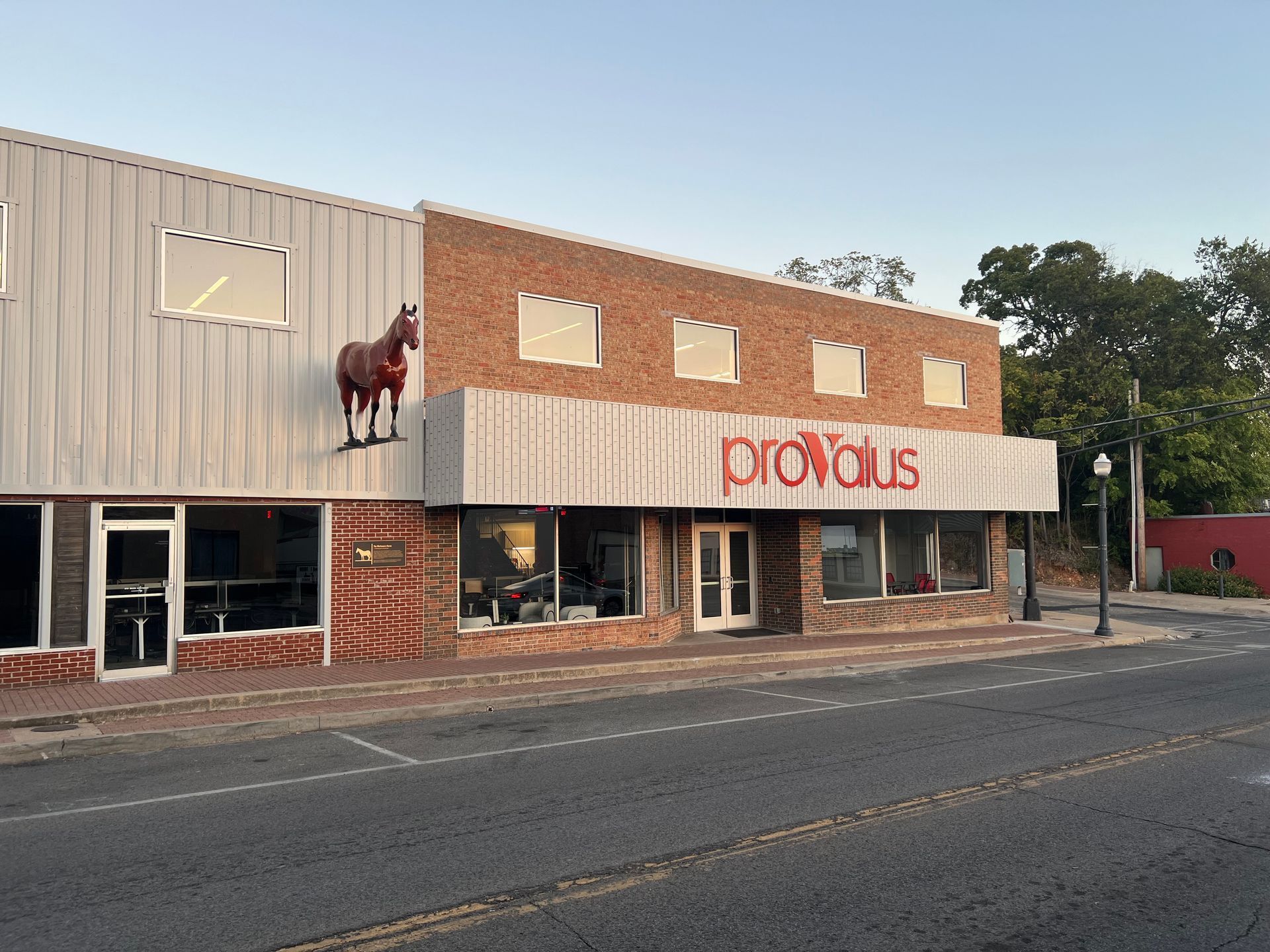 A statue of a horse is on the side of a building.