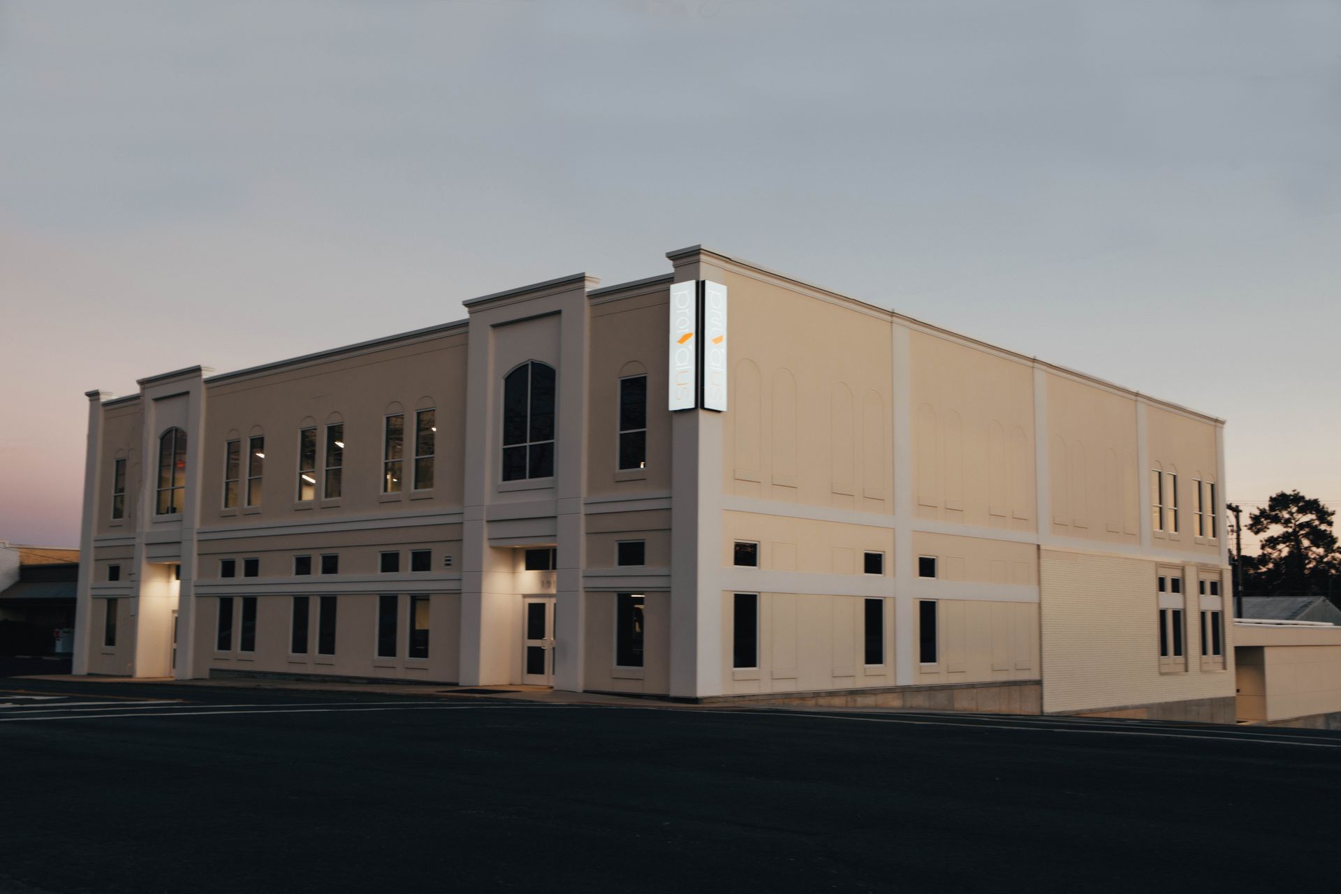 A large building with a lot of windows is lit up at night.