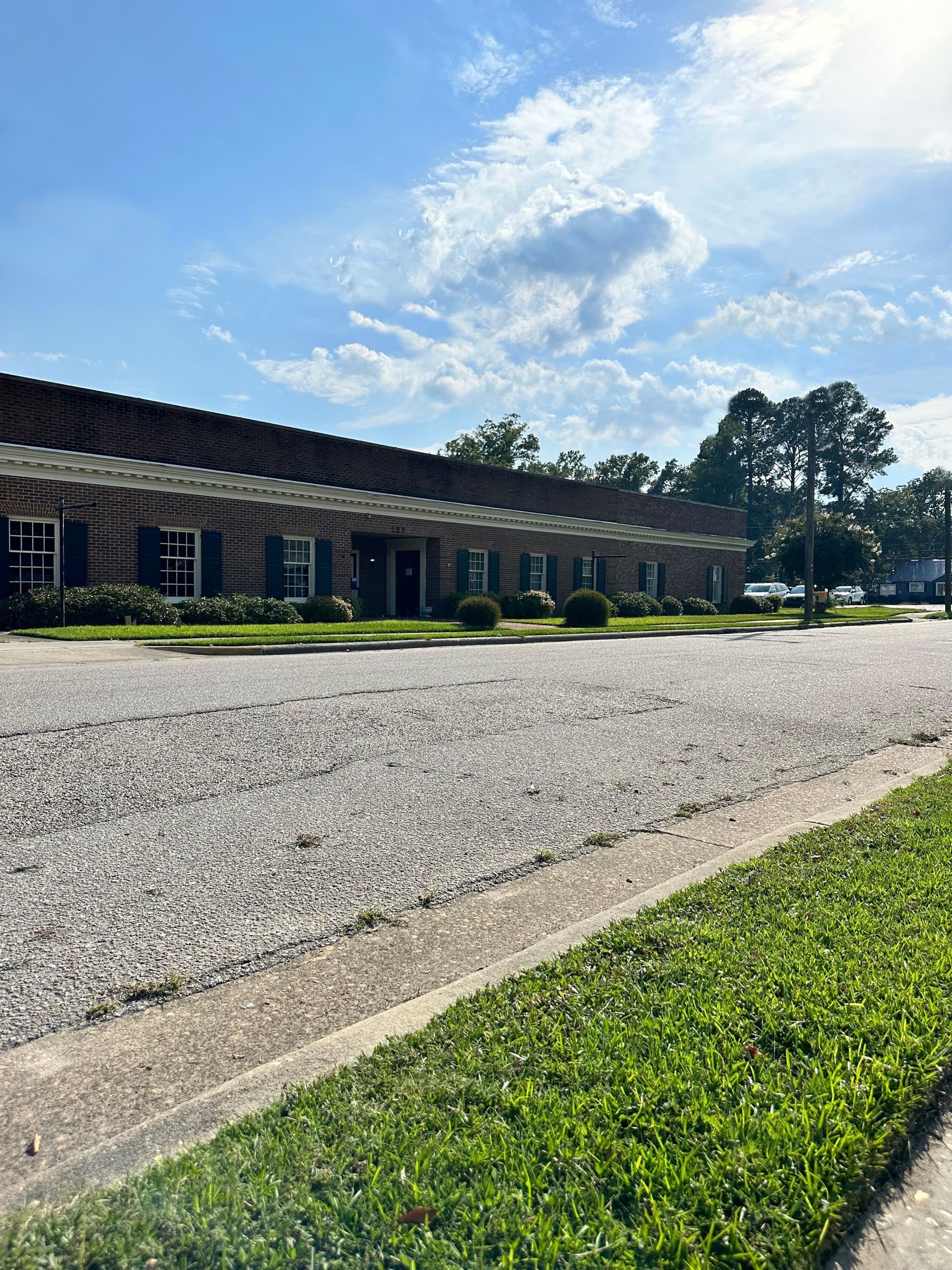 A large brick building with a gravel driveway in front of it.