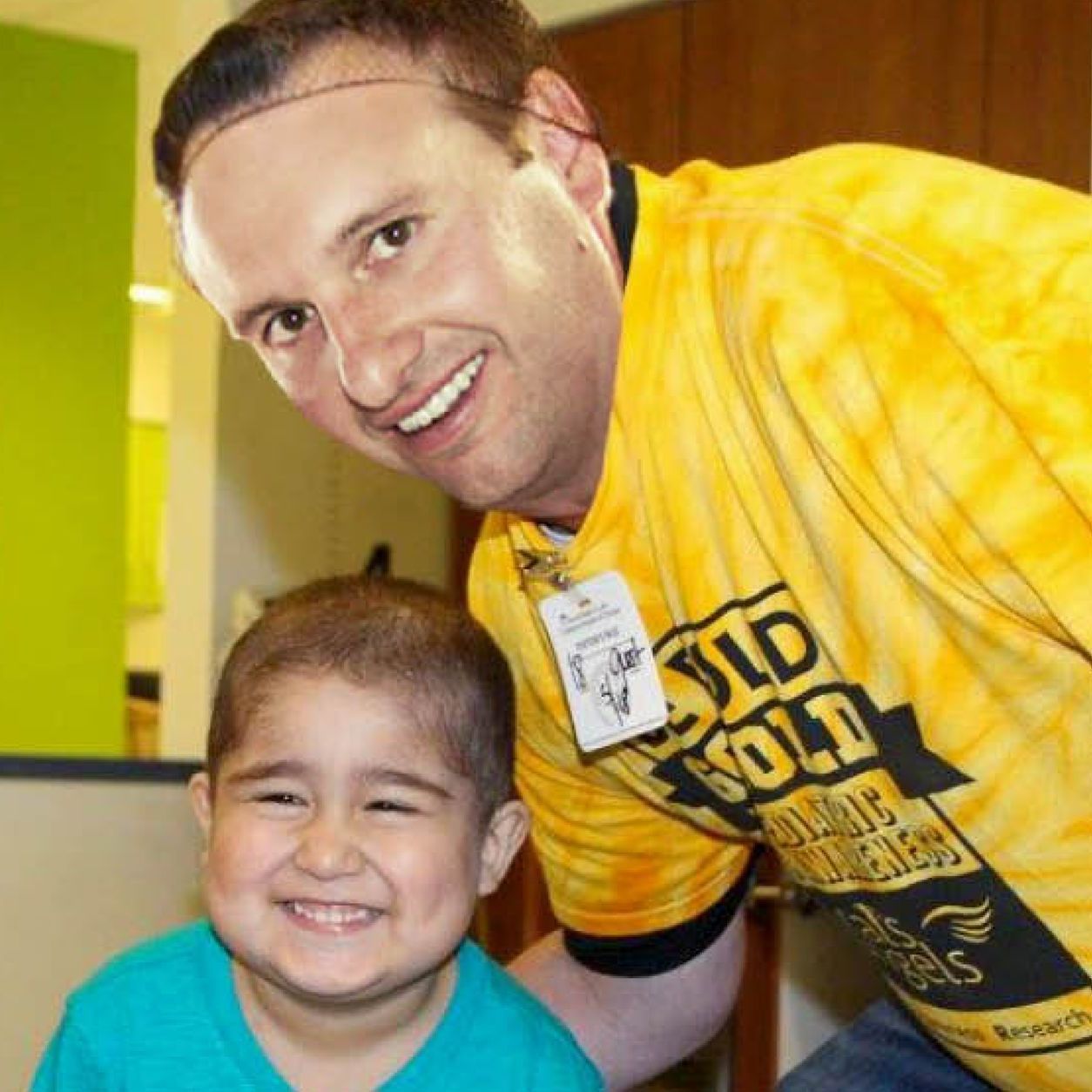 A man wearing a yellow shirt that says old gold