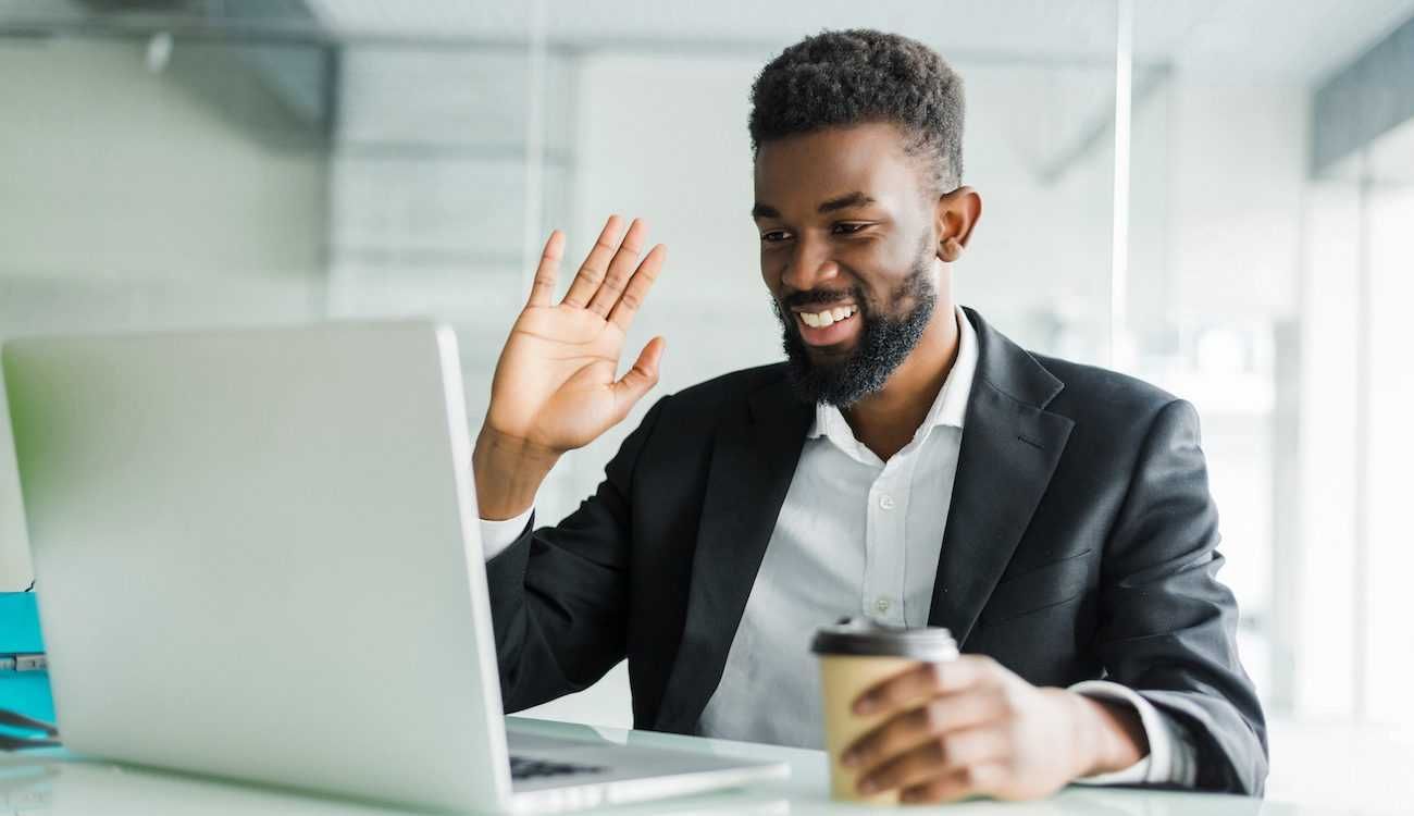 A man in a suit is sitting in front of a laptop computer.