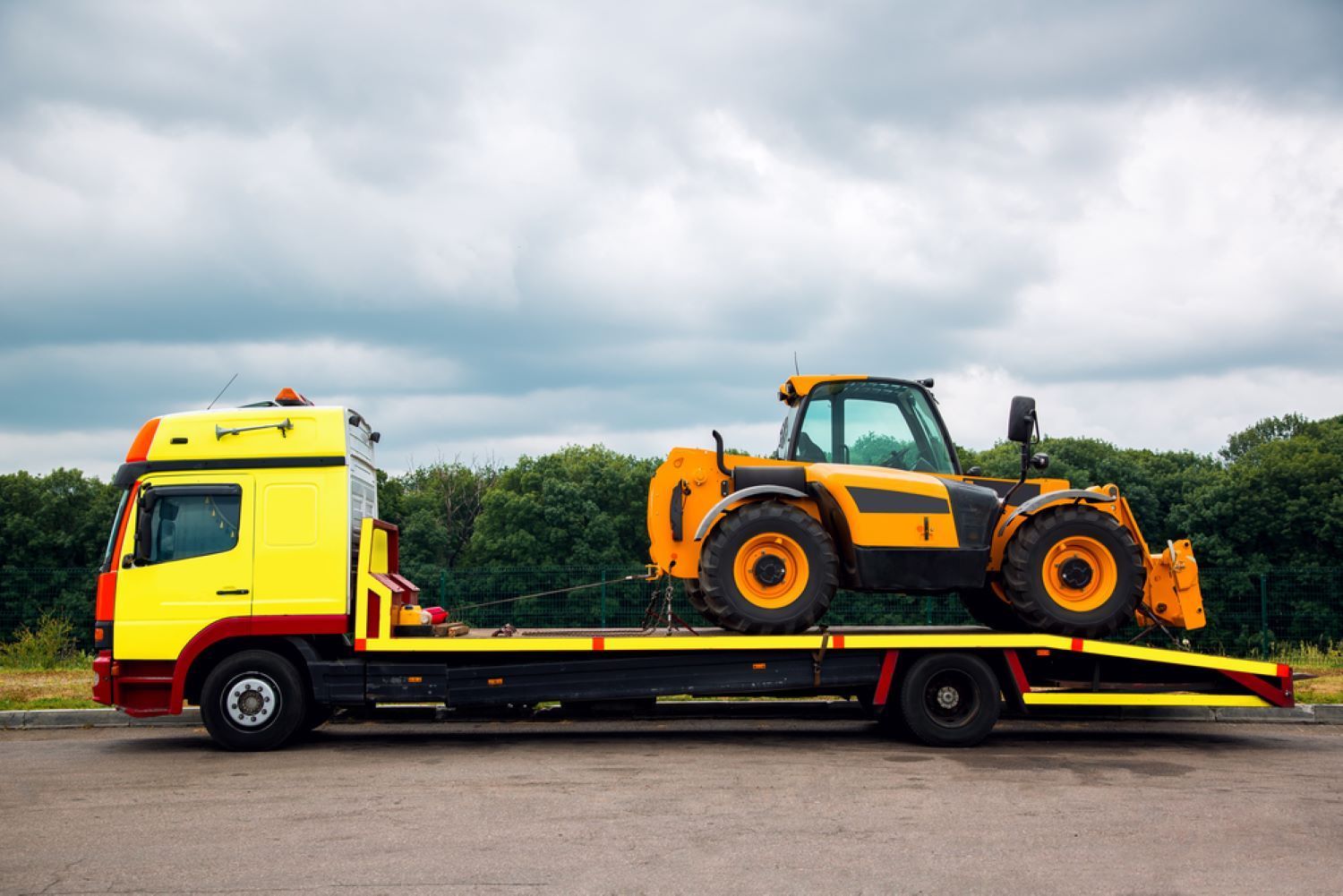 A Yellow Tow Truck is Carrying a Yellow Tractor — Aura Towing Service in Baringa, QLD