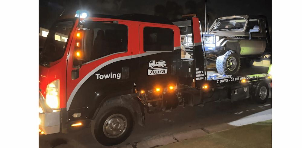 Tow Truck With a Vehicle on Its Flatbed at Night — Aura Towing Service in Banya, QLD 