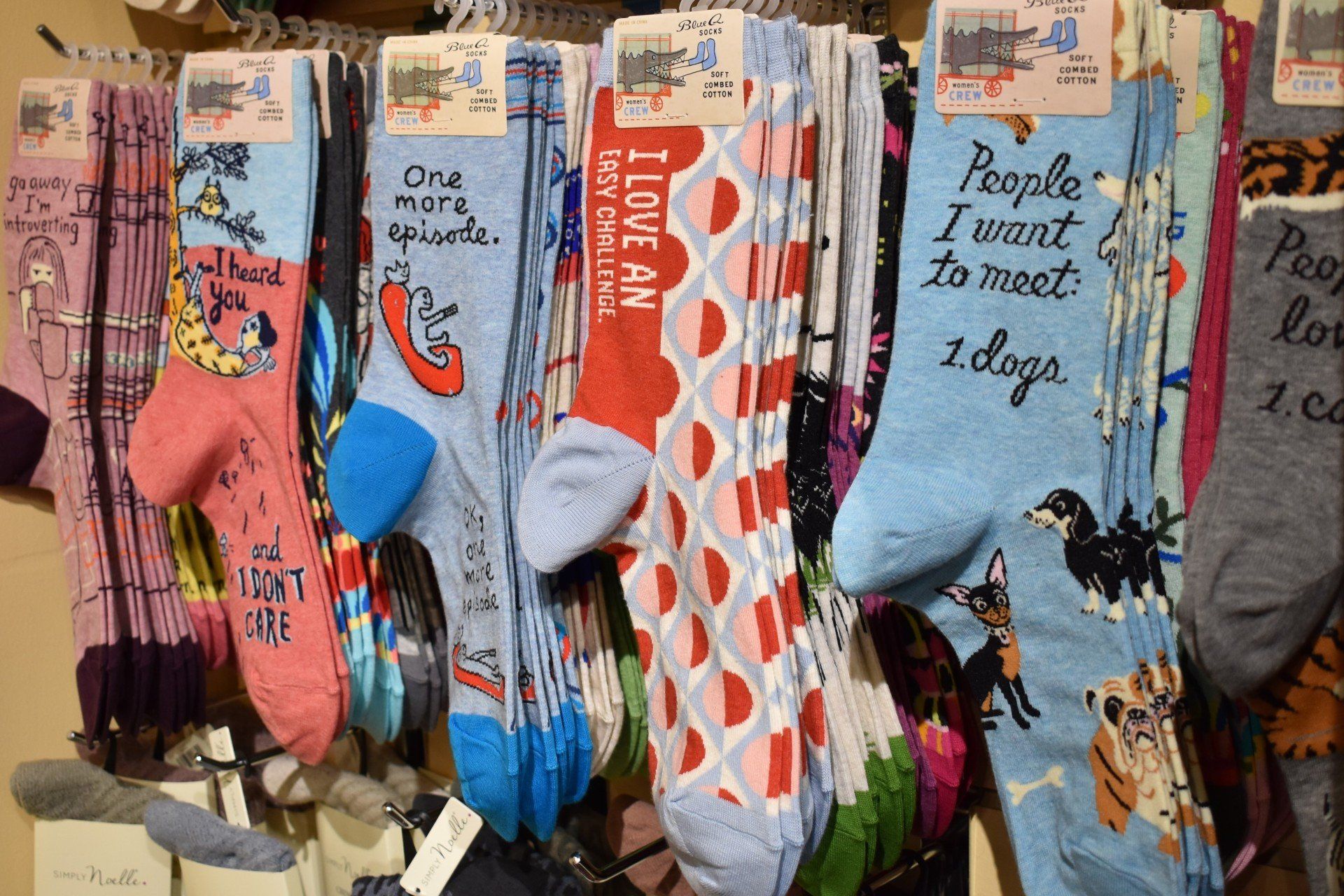 A bunch of socks hanging on a shelf with one that says i love my dogs