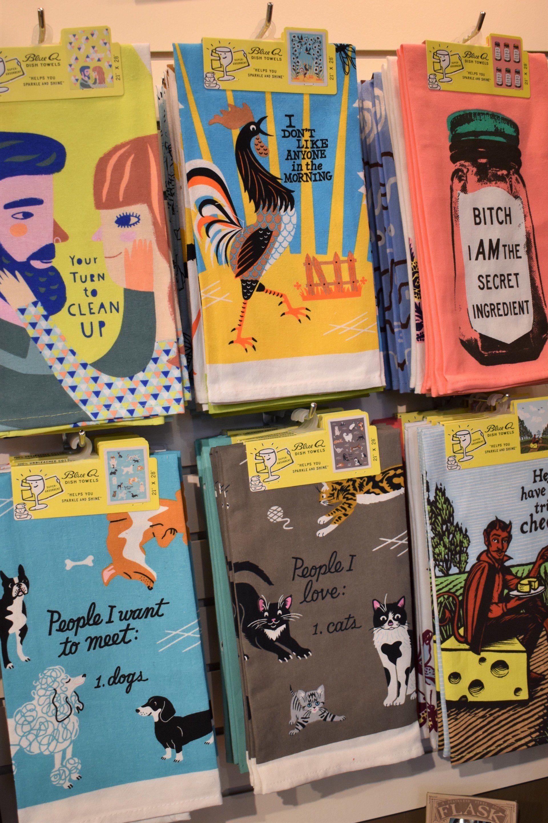 A bunch of towels hanging on a wall with one that says people i want to meet dogs