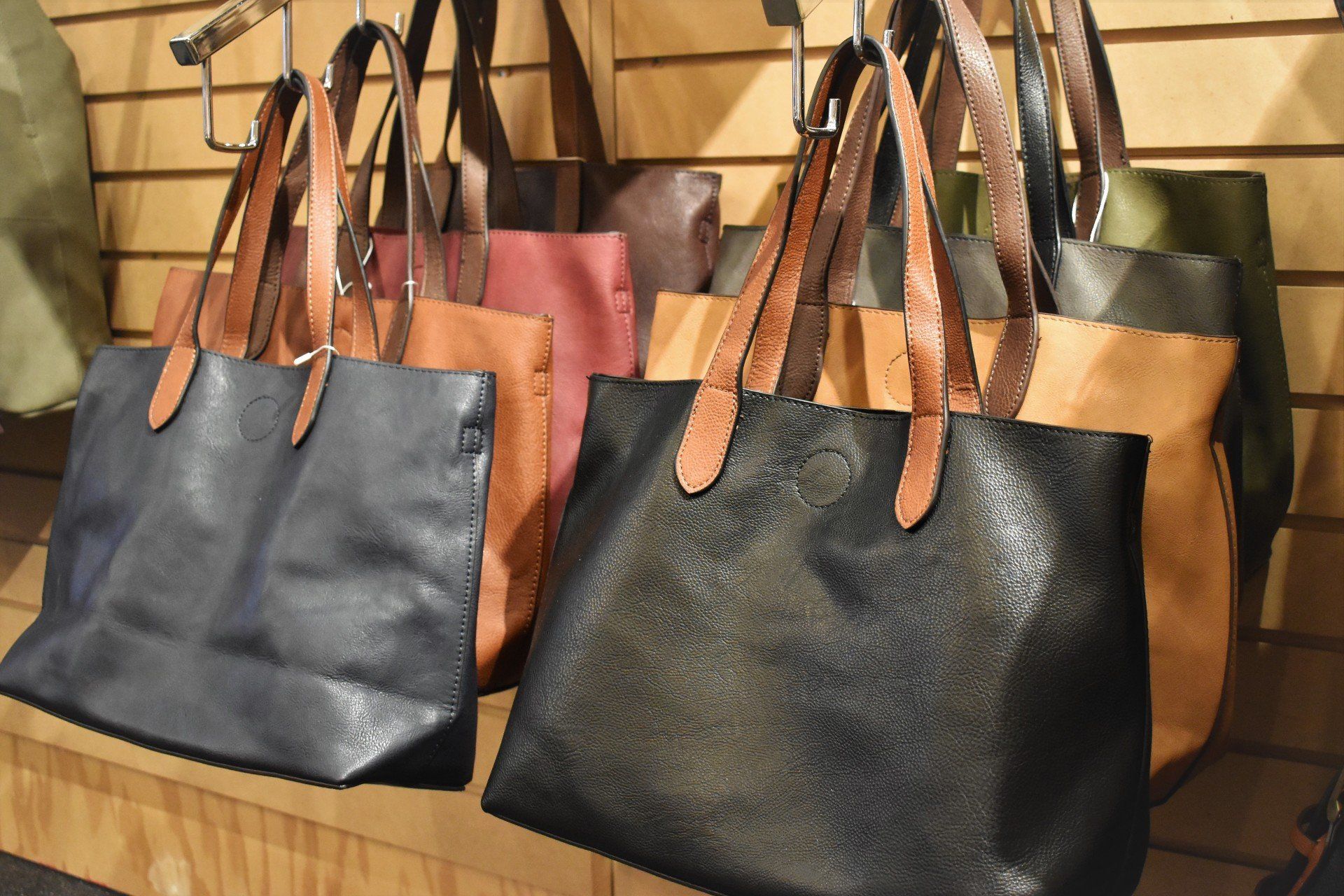 A bunch of handbags are hanging on a wall