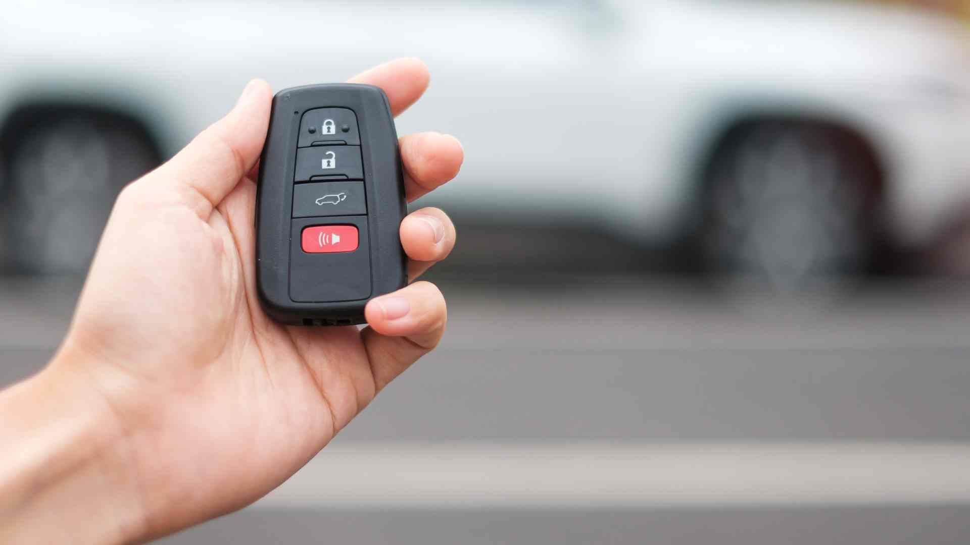 Person's hand holding a key fob outside a vehicle at King's Locksmiths near Lexington, KY