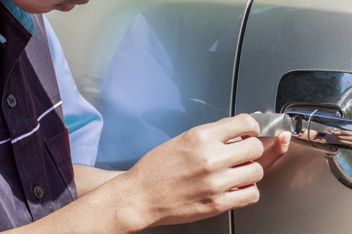 Automotive locksmith near Lexington, KY, using a tool to open a car door