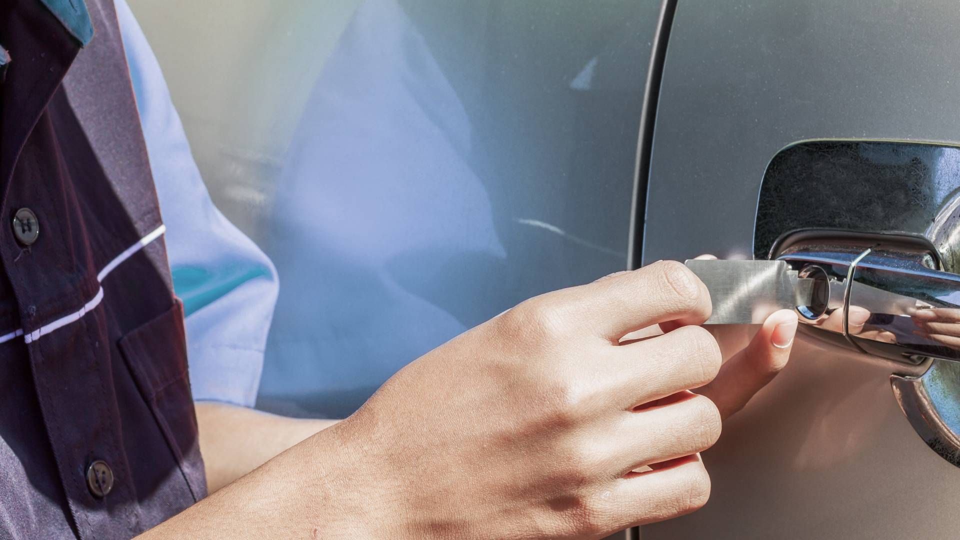 Automotive locksmith near Lexington, KY, using a tool to open a car door