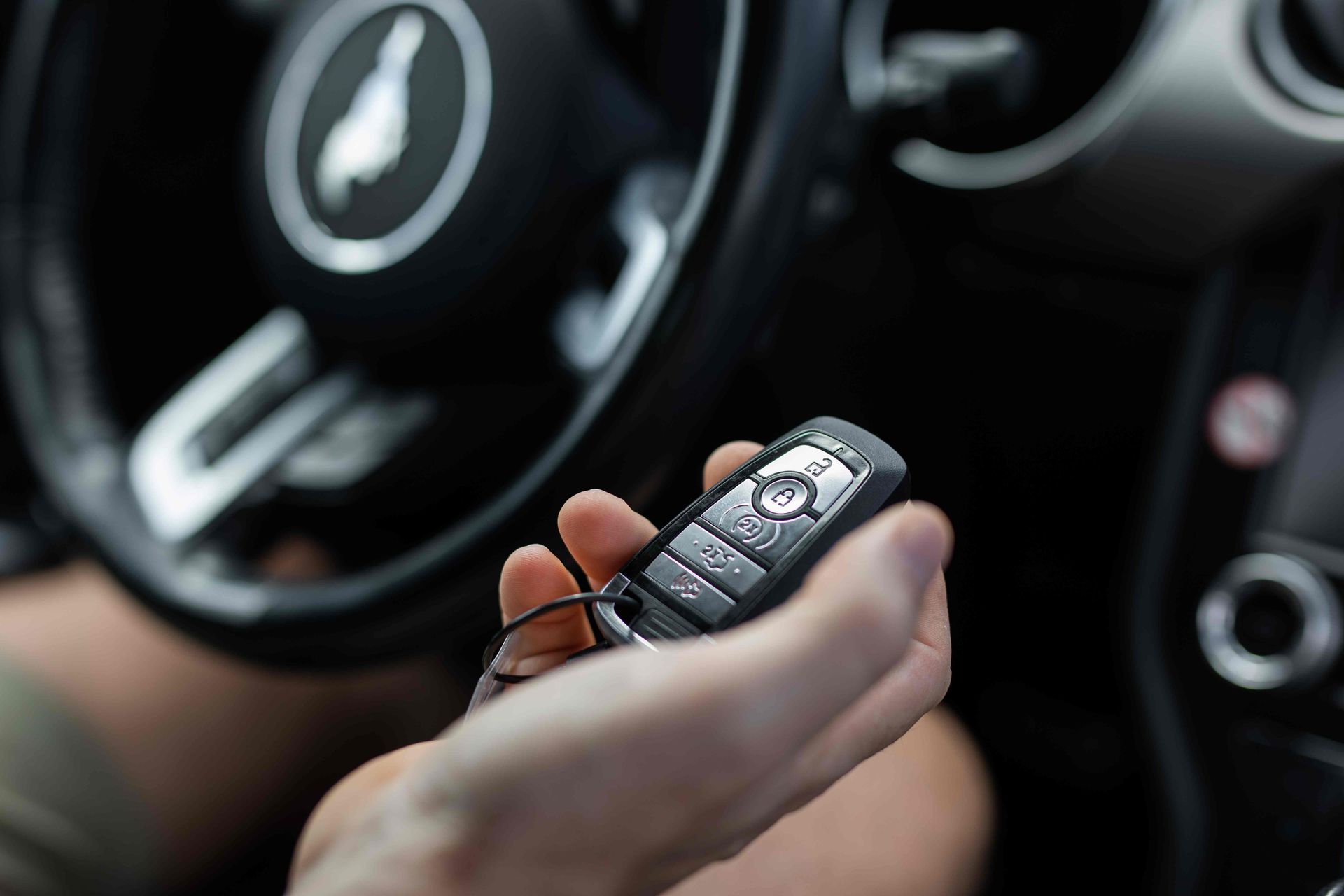 Person's hand holding a key fob inside of a car at King's Locksmiths near Lexington, KY