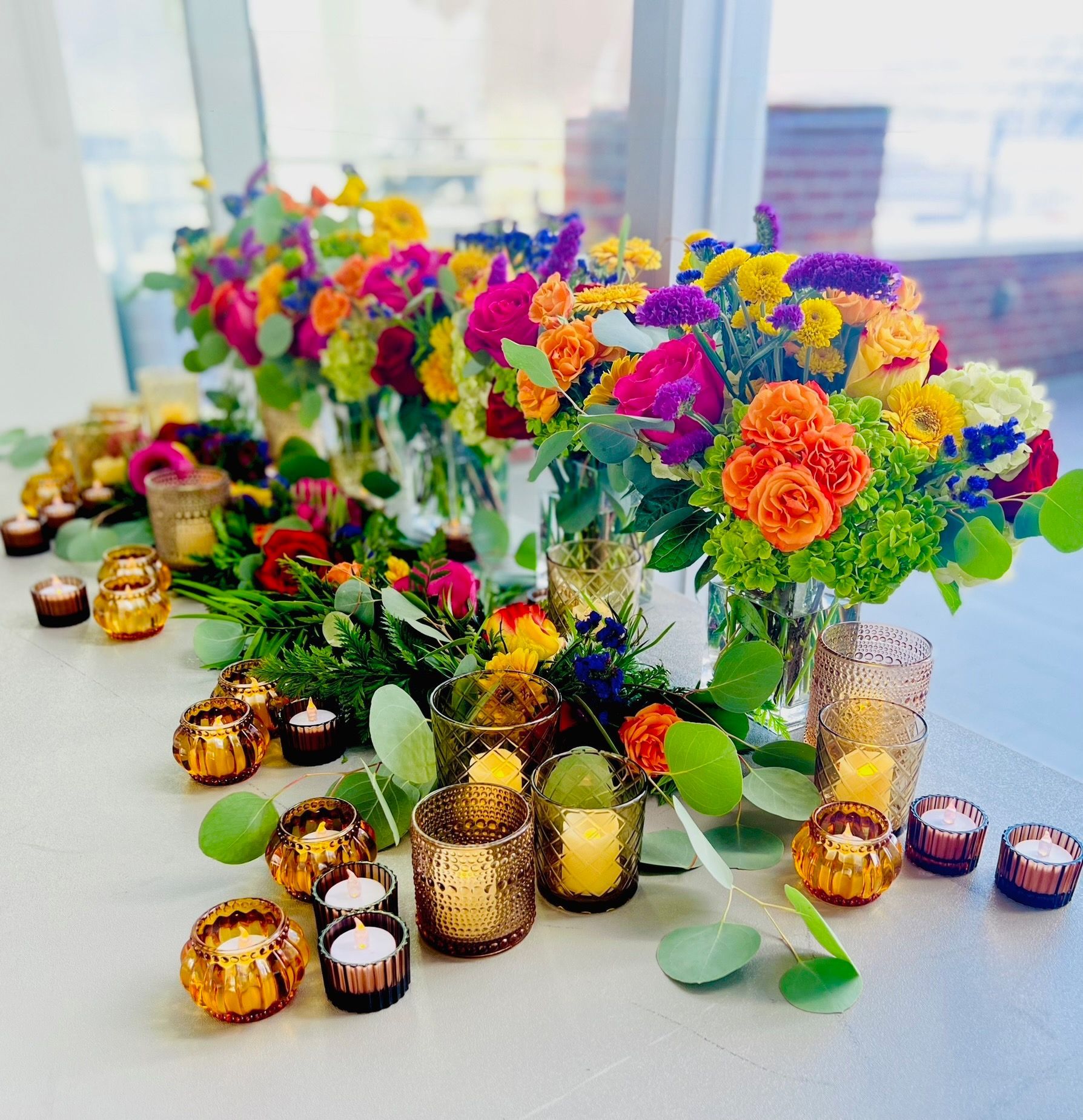 Bright colorful arrangements, amber votive candles