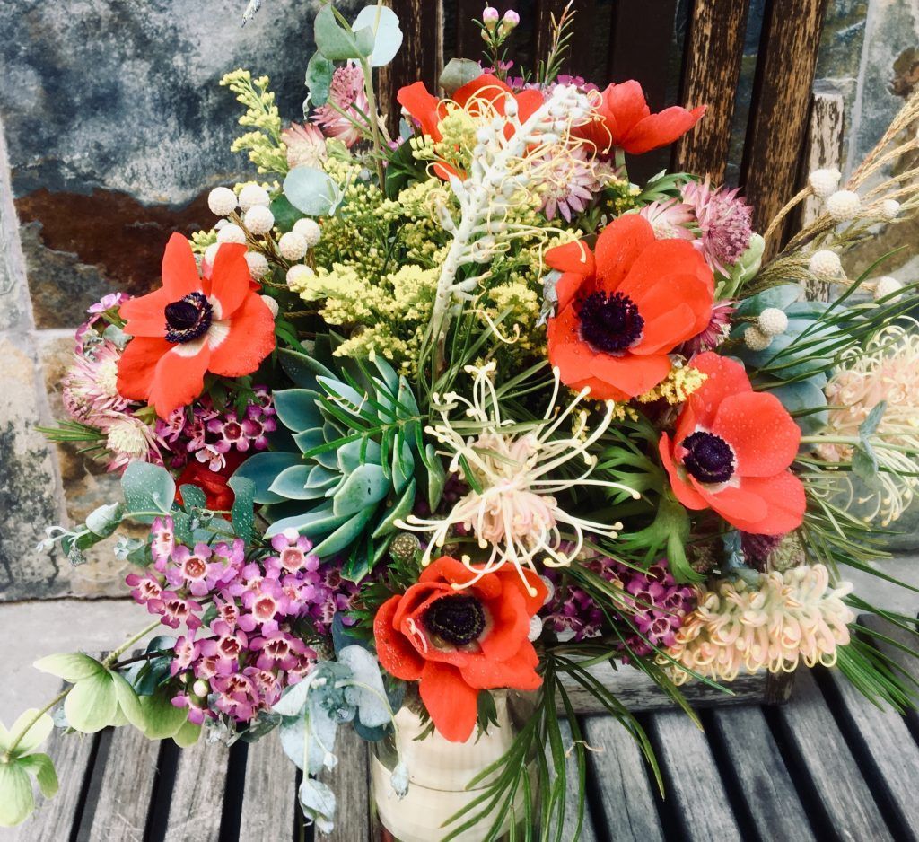 A vase filled with flowers is sitting on a wooden table.