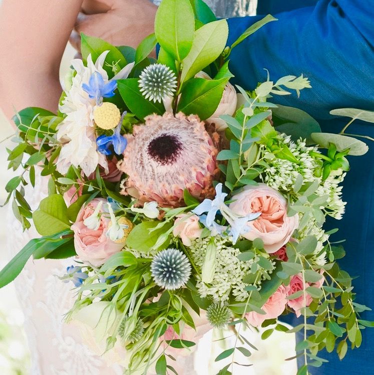 A bride and groom are holding a bouquet of flowers