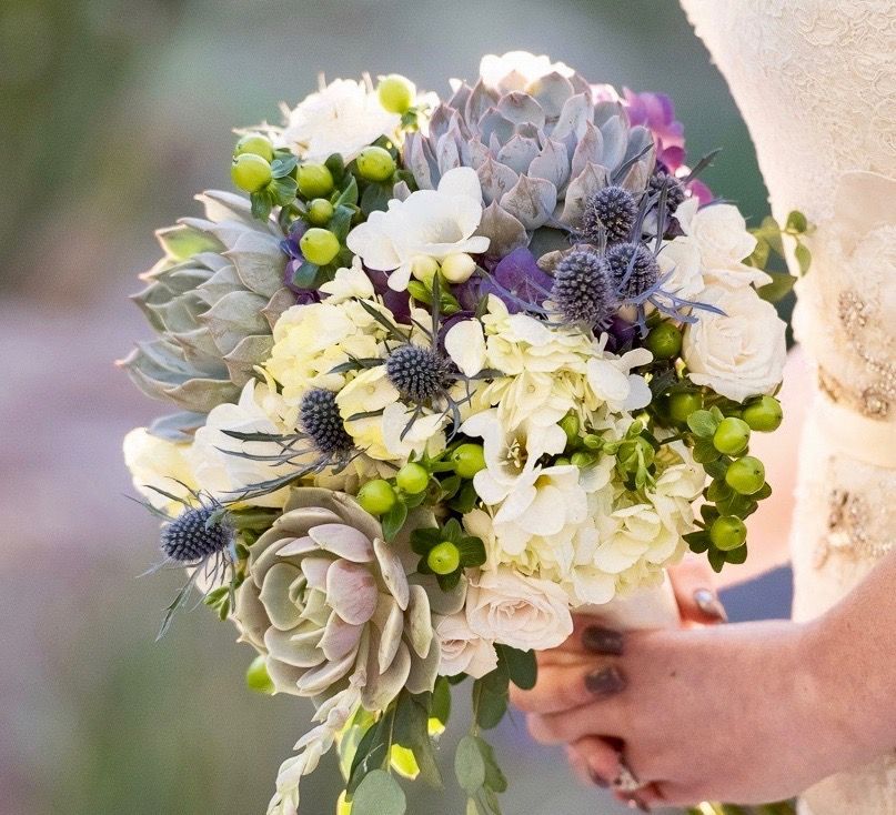A woman in a white dress is holding a bouquet of flowers