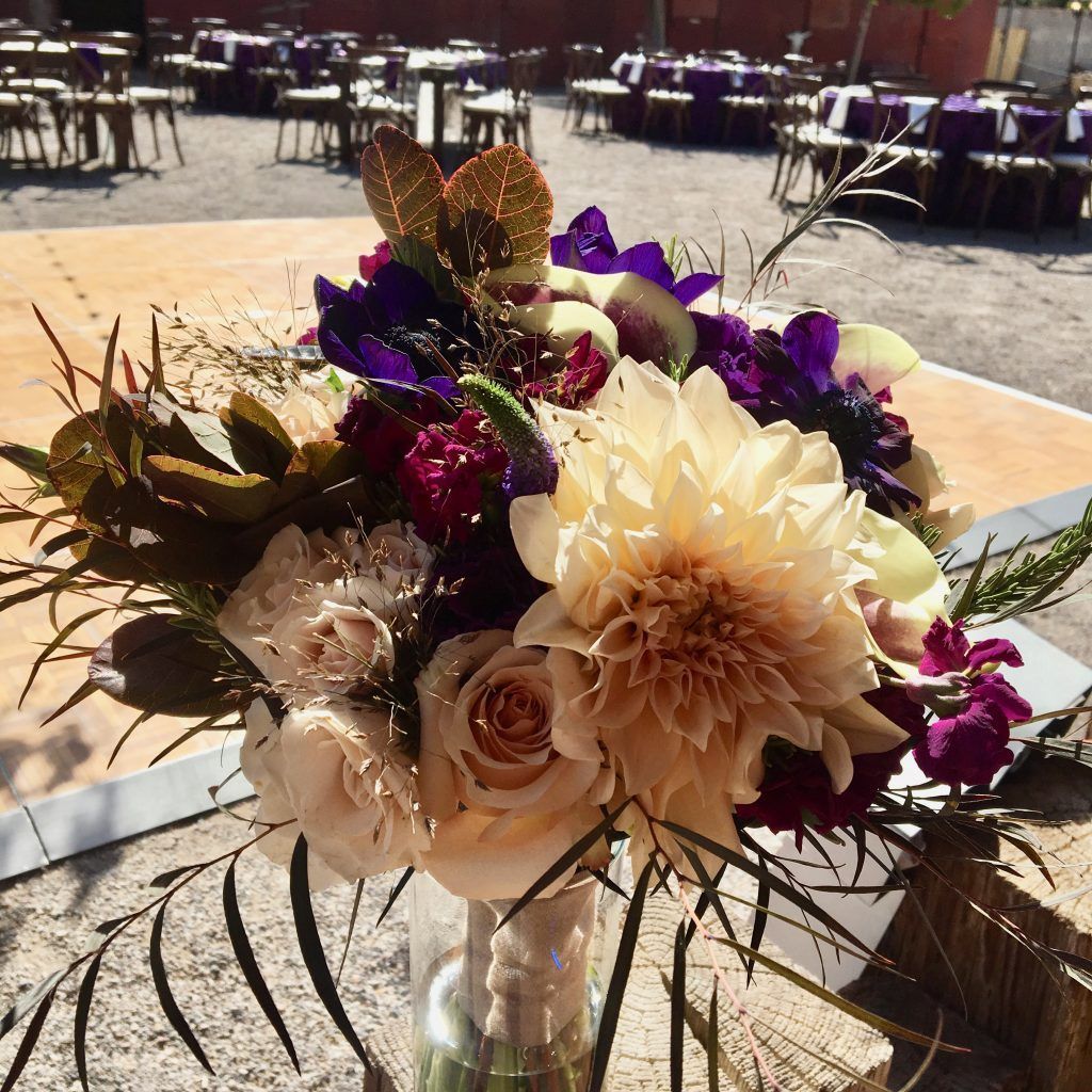 A vase filled with purple and white flowers is sitting on a table.