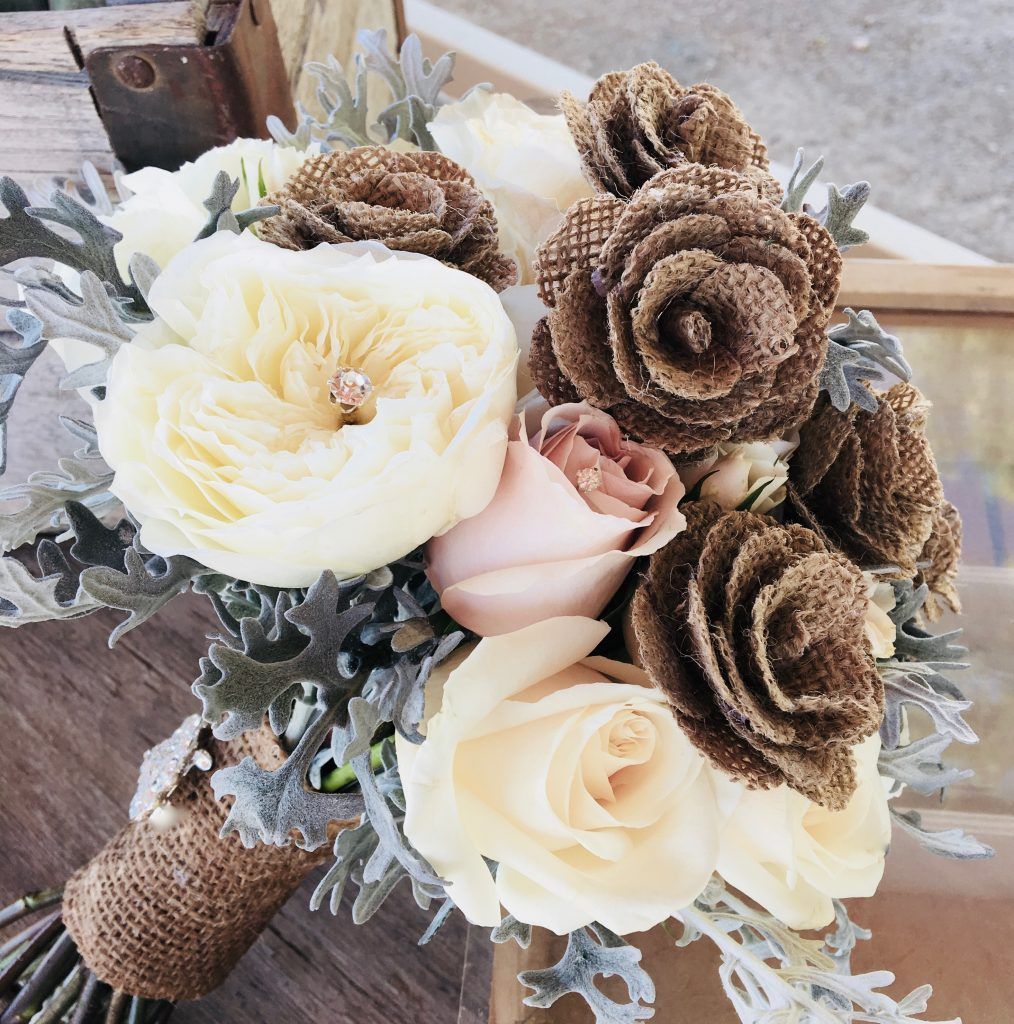 A bouquet of flowers with burlap roses and leaves