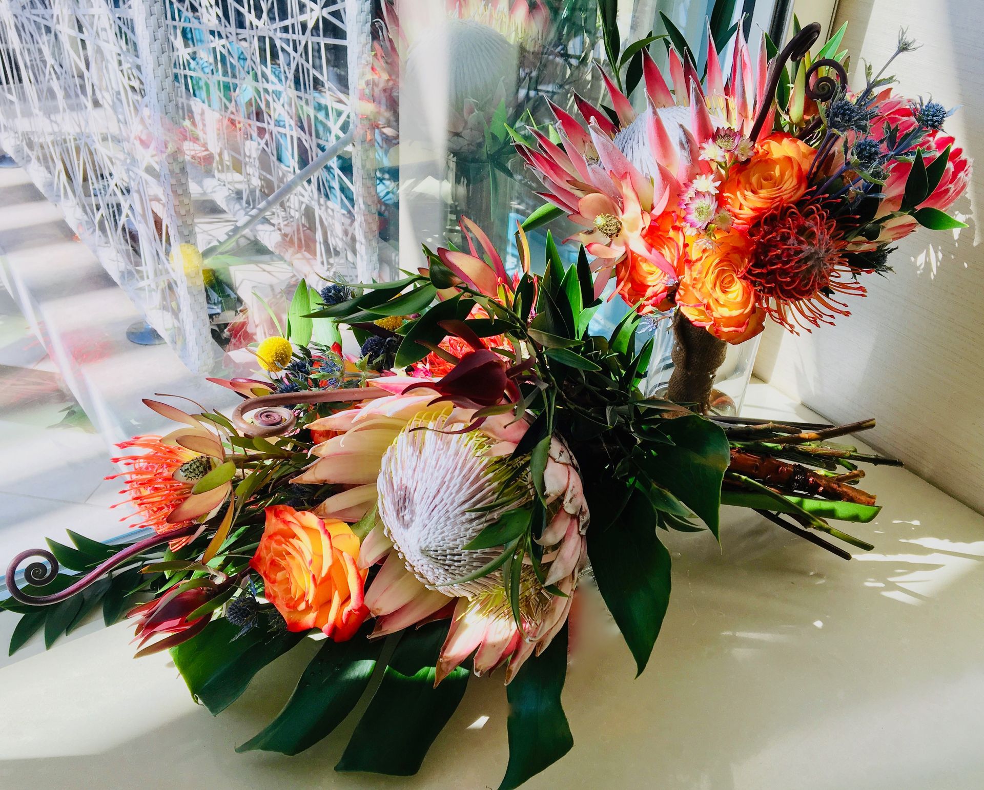 A bouquet of flowers is sitting on a table in front of a window.