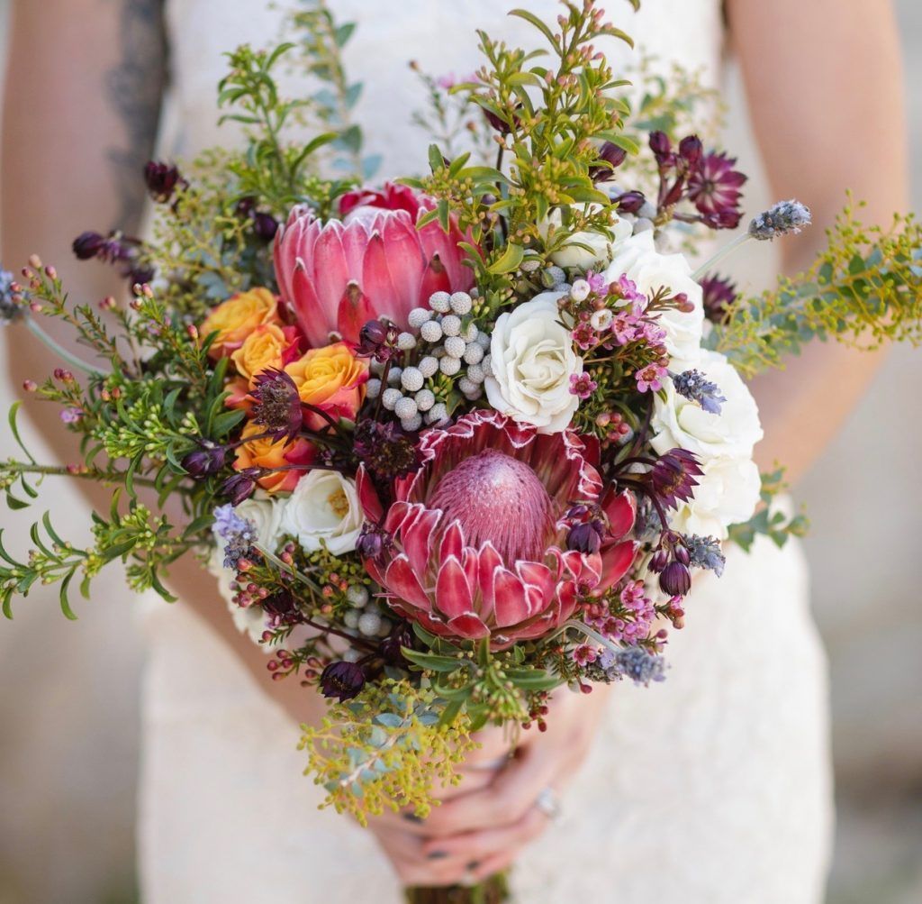 A woman in a white dress is holding a bouquet of flowers.