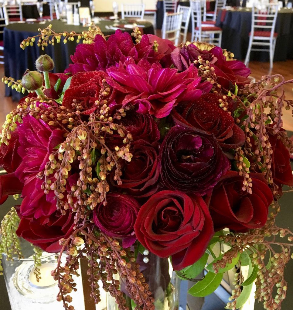 A vase filled with red flowers sits on a table