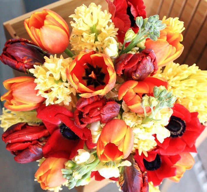 A bouquet of red and yellow flowers in a wooden box