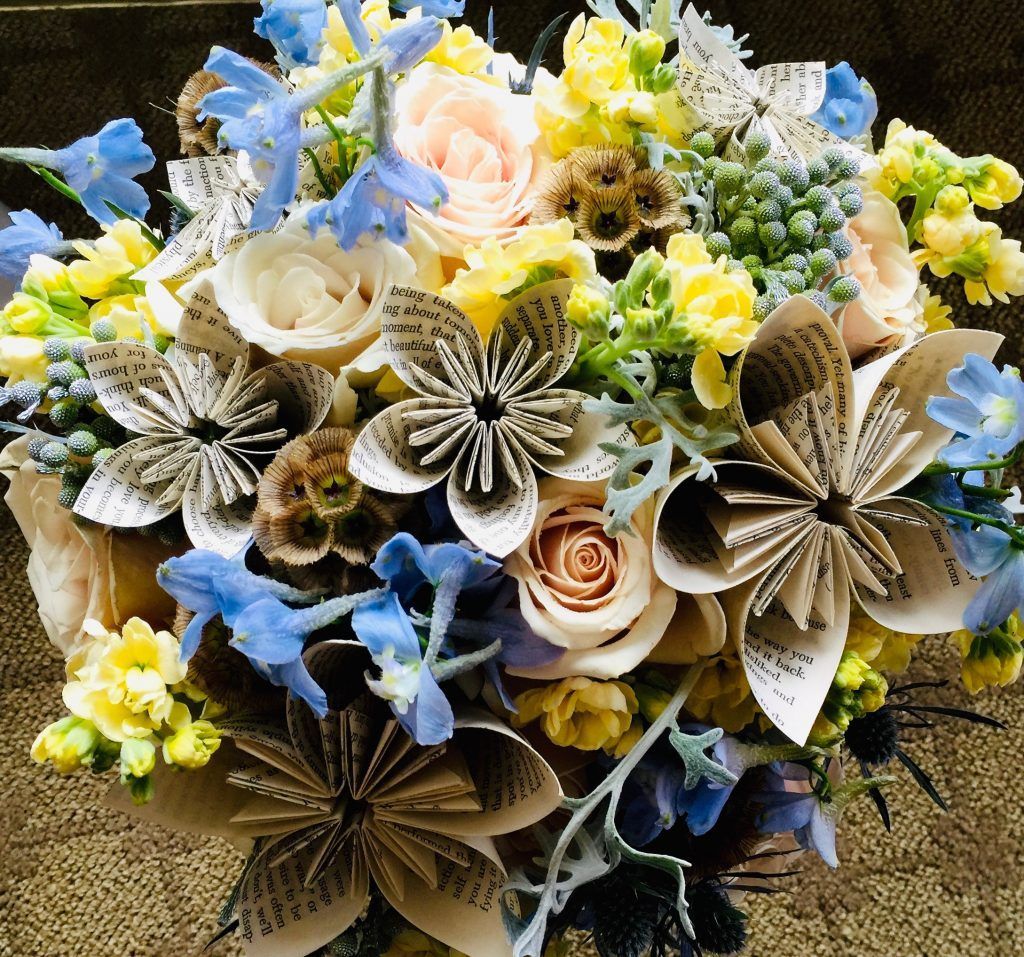 A bouquet of yellow and blue flowers made out of book pages