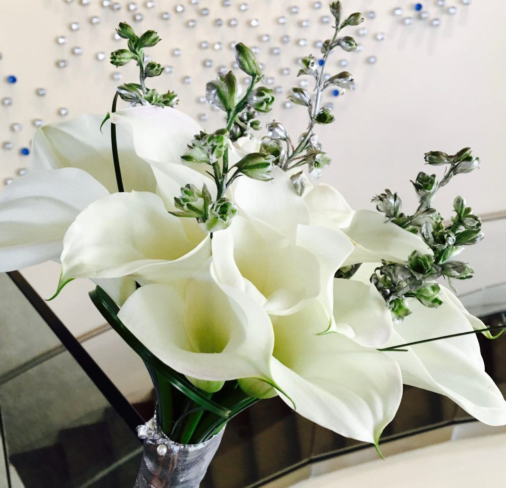 A vase filled with white flowers sits on a table