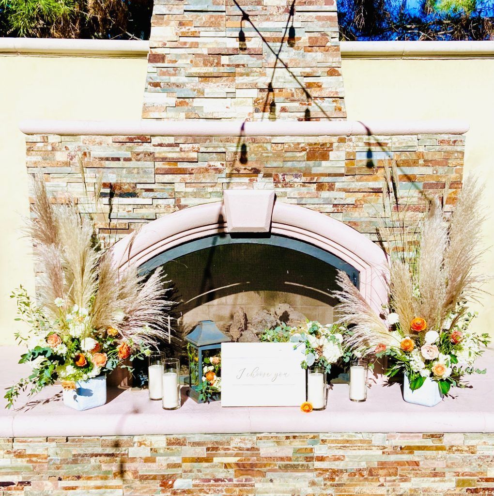 A stone fireplace with flowers and candles on it