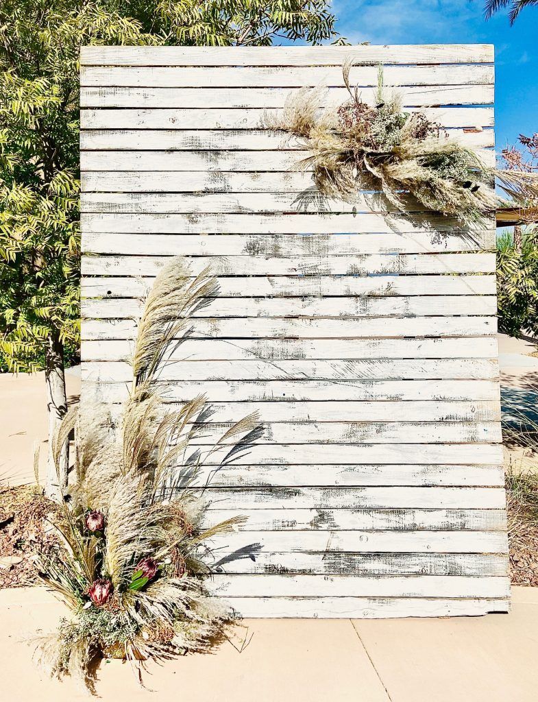 A white wooden wall with flowers on it.