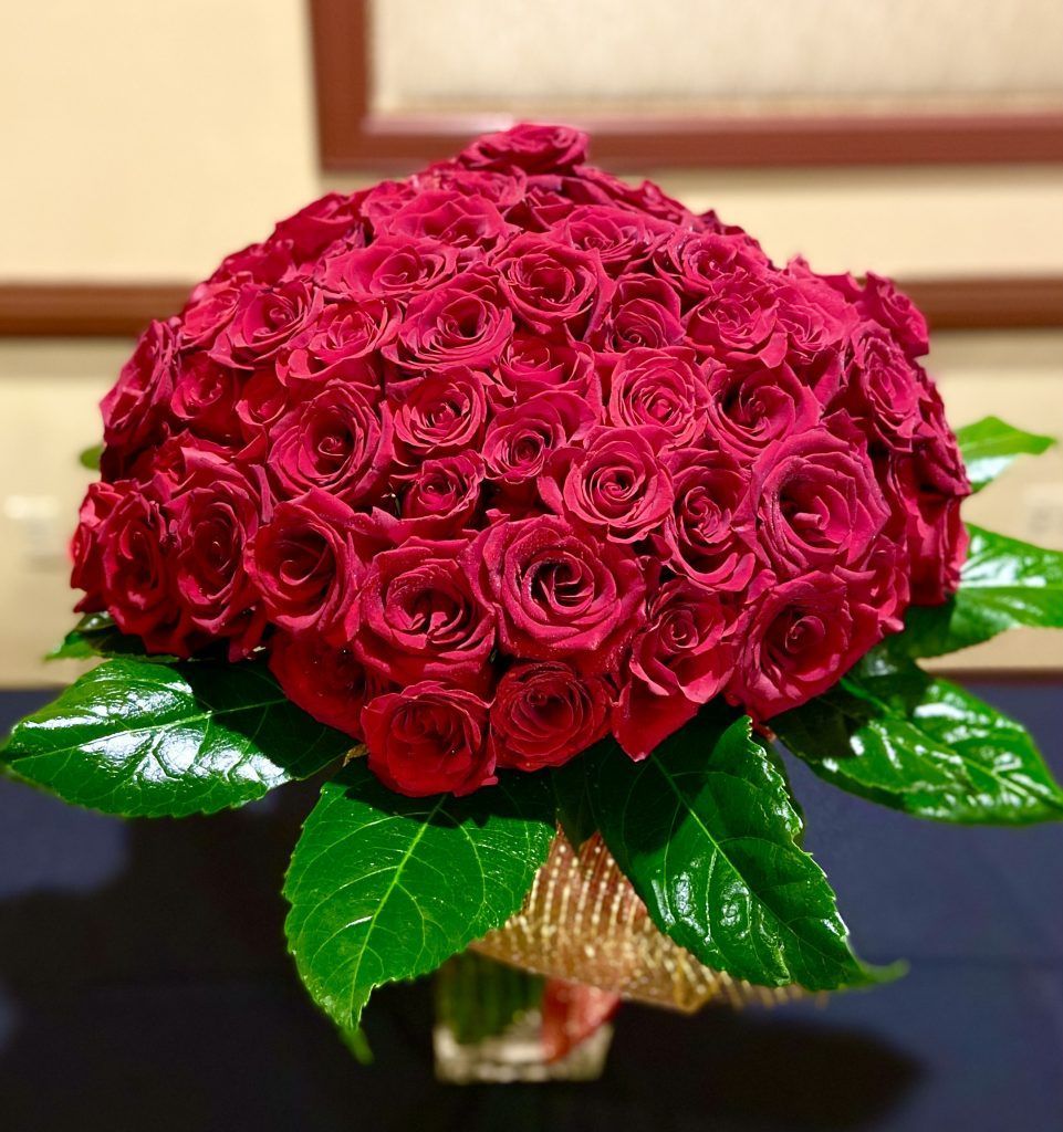 A bouquet of red roses in a vase on a table