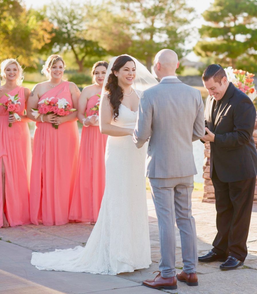 A bride and groom are standing in front of their wedding party