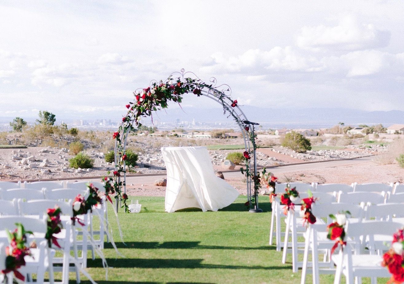 A wedding ceremony is taking place in the middle of a grassy field.