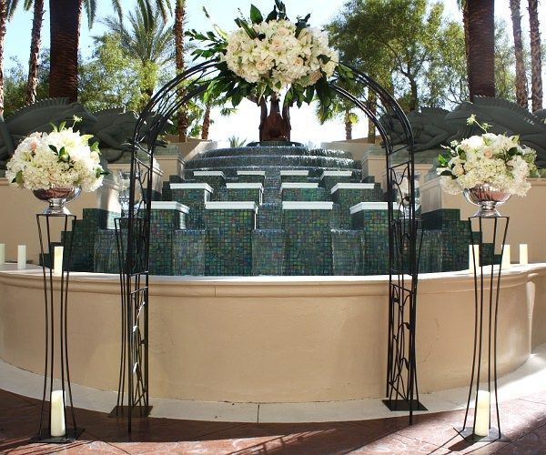 A fountain is decorated with white flowers and candles