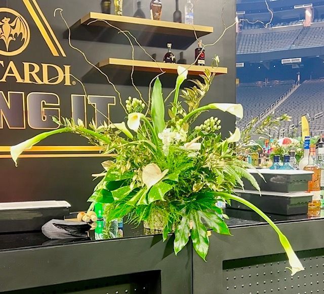 A bouquet of flowers in front of a sign that says bacardi