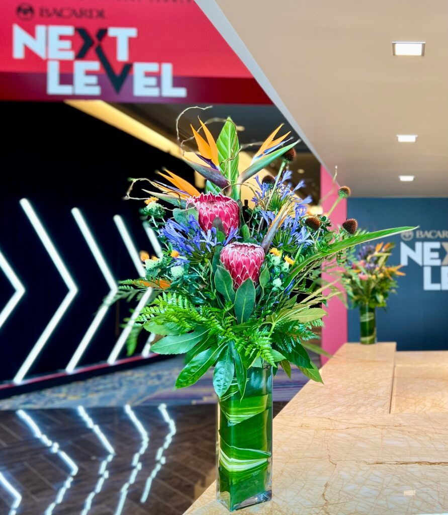 A vase of flowers in front of a sign that says next level
