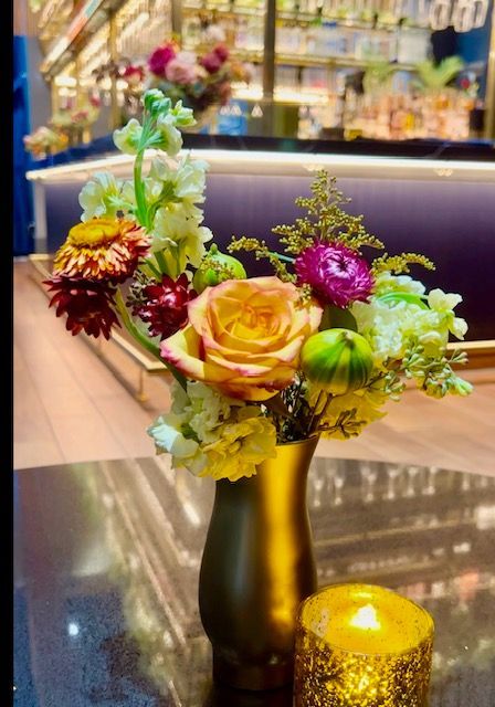 A vase filled with flowers and a candle on a table