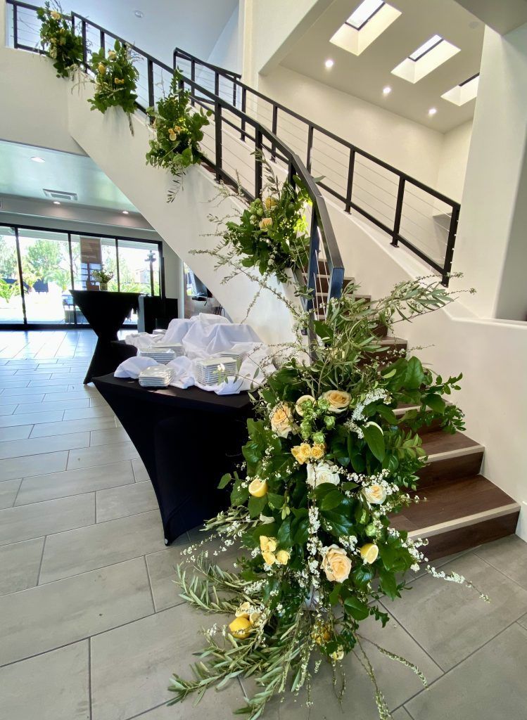 A staircase is decorated with flowers and greenery.