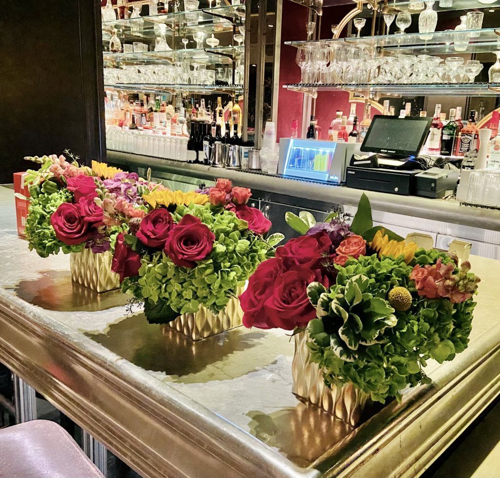A row of vases filled with flowers on a counter
